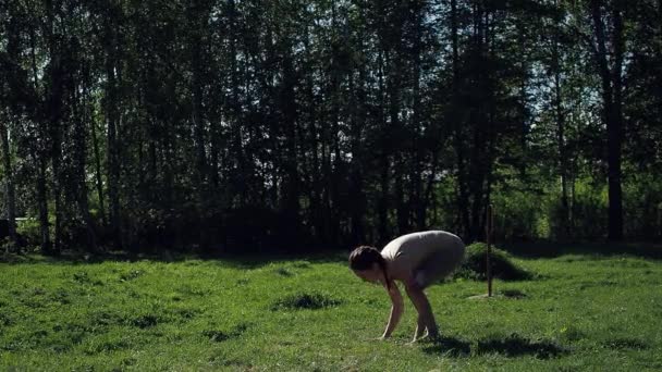 Femme faisant du yoga dans le parc — Video