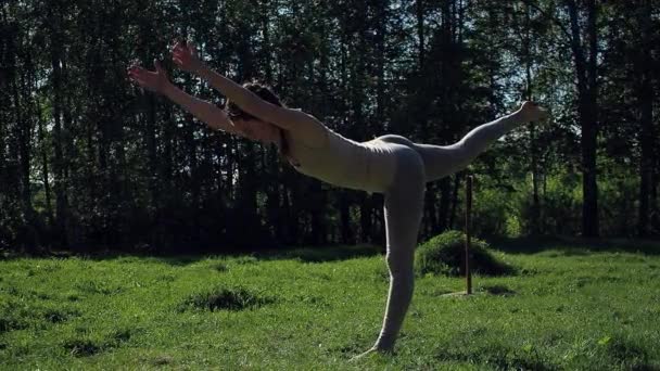 Vrouw doet yoga in het park — Stockvideo