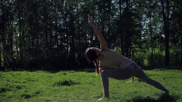 Vrouw doet yoga in het park — Stockvideo