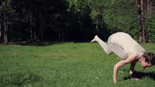 Vrouw doet yoga in het park — Stockvideo