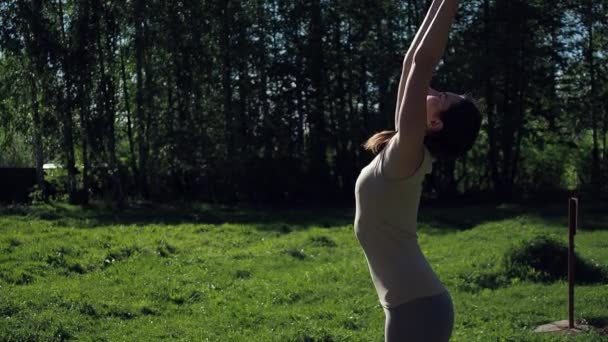 Vrouw doet yoga in het park — Stockvideo