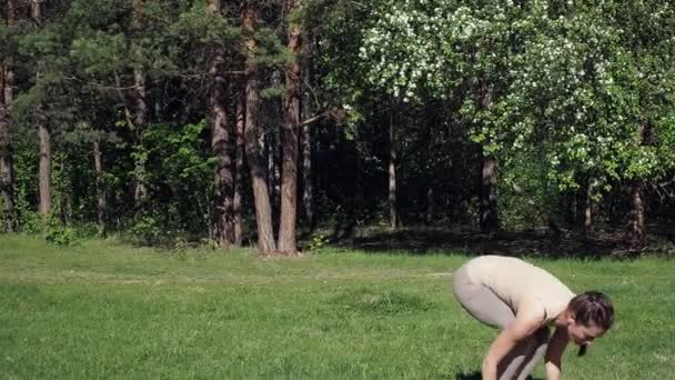 Γυναίκα κάνει γιόγκα στο πάρκο — Αρχείο Βίντεο