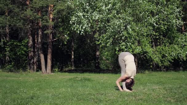 Жінка робить йогу в парку — стокове відео