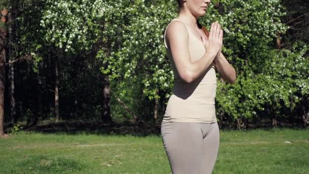 Vrouw doet yoga in het park — Stockvideo