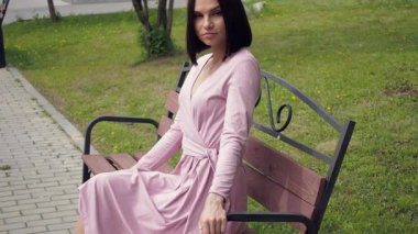 Zarif bir genç esmer parkta bankta dinleniyor.