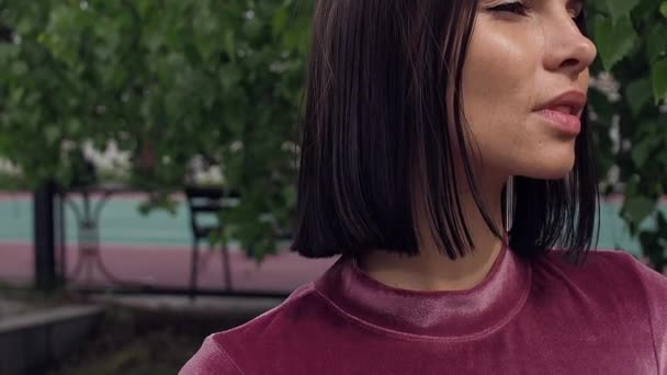 Доросла приваблива брюнетка в літньому парку — стокове відео