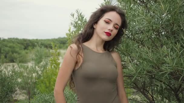 Красива жінка торкається волосся на пляжі — стокове відео