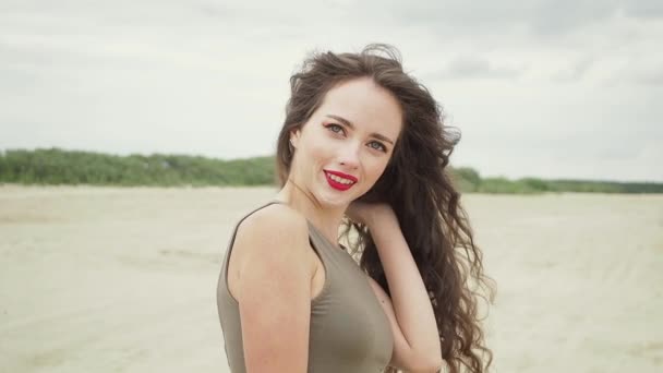 Mujer bonita tocando el pelo en la playa — Vídeos de Stock