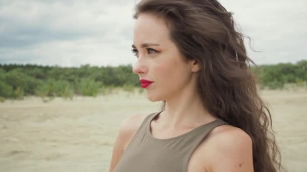 Όμορφη γυναίκα αγγίζει τα μαλλιά στην παραλία — Αρχείο Βίντεο