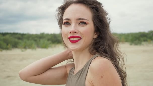 Hübsche Frau berührt Haare am Strand — Stockvideo