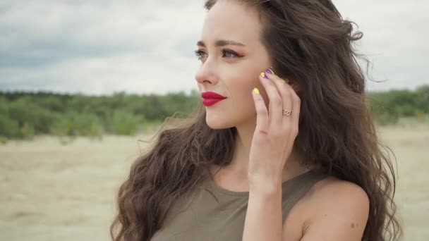 Mujer bonita tocando el pelo en la playa — Vídeos de Stock