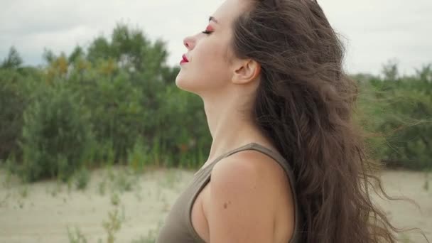 Красивая женщина трогает волосы на пляже — стоковое видео