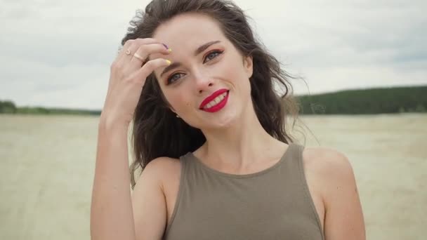 Mujer bonita tocando el pelo en la playa — Vídeos de Stock