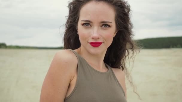 Mujer bonita tocando el pelo en la playa — Vídeos de Stock