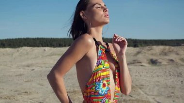 Mayo giymiş sıska bir kadın başka tarafa bakıyor.