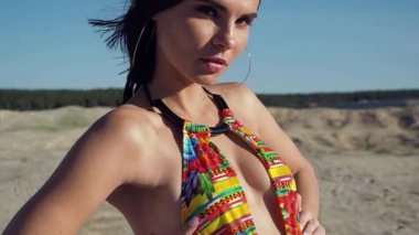 Mayo giymiş sıska bir kadın başka tarafa bakıyor.