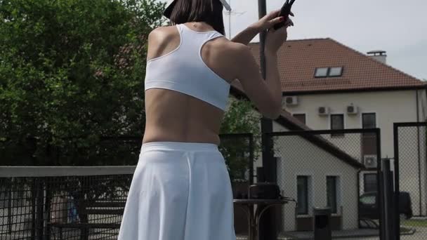 Земледелька играет в теннис на корте — стоковое видео