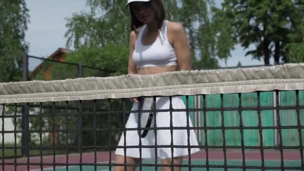 Кукурудзяна жінка грає в теніс на корті — стокове відео