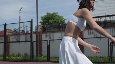 Sahada tenis oynayan kırsal kadın.