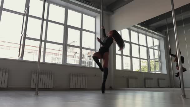 Stüdyoda direğin üstünde dans eden esnek bir kadın. — Stok video