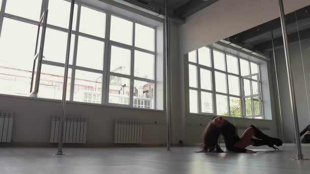 Flexibel kvinna dansar på stolpe i studio — Stockvideo