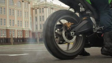 Motosikletli bir motorcu duman içinde sürükleniyor.
