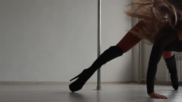 Гибкая женщина танцует на шесте в студии — стоковое видео