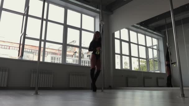 Flexibel kvinna dansar på stolpe i studio — Stockvideo