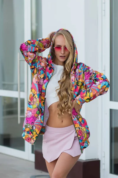 Slim Blond Woman Adjusting Hood Colorful Stylish Jacket Looking Away — Stock Photo, Image