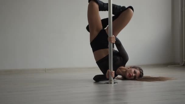 Fleksibel kvinne danser på pole i studio – stockvideo