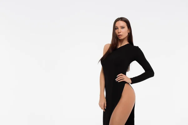 サイドビューの官能的な女性でセクシー黒ドレス見ますカメラに対して白の背景 — ストック写真