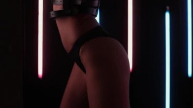 Gece kulübünde iç çamaşırlı fit bir kadın dans ediyor.