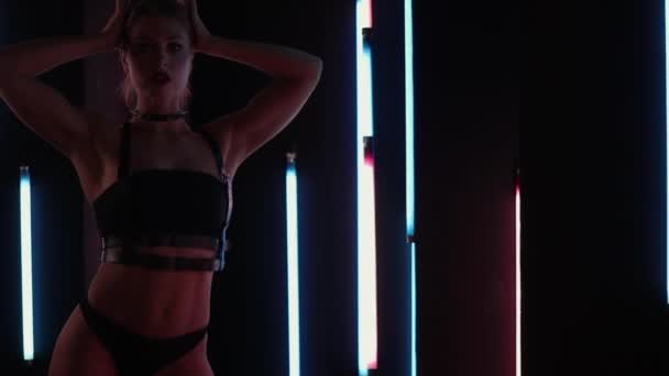 Vrouwelijke stripper dansen in neon lichten — Stockvideo