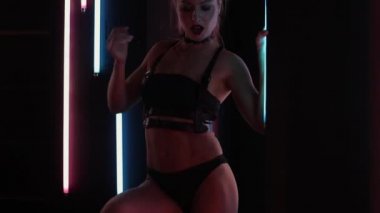 Neon ışıklarında dans eden kadın striptizci.