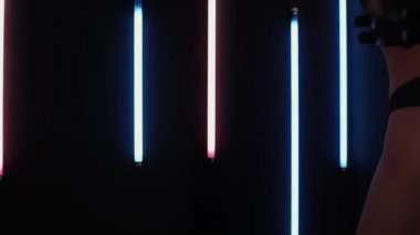 Neon ışıklarında dans eden kadın striptizci.