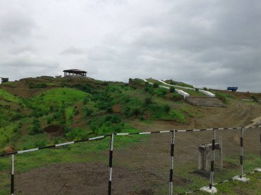 Huzurevi olan çitlerle kaplı küçük dağ sıraları.