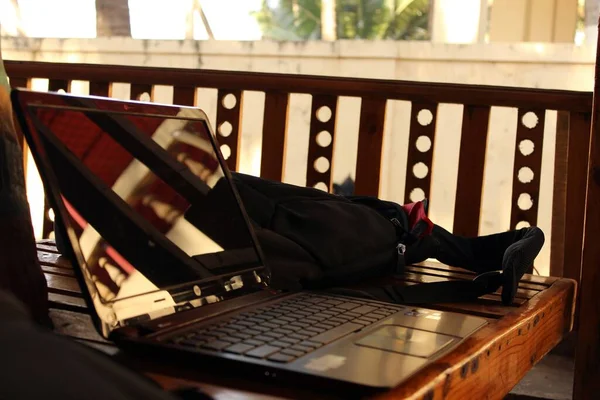 Tahta masada siyah çantalı bir laptop.