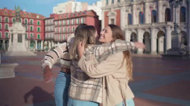 Avrupa şehir meydanında sarılan üç mutlu çok ırklı arkadaş