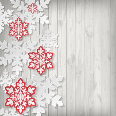 Ahşap arka plan üzerinde kağıt kar taneleri ile Noel tebrik kartı.
