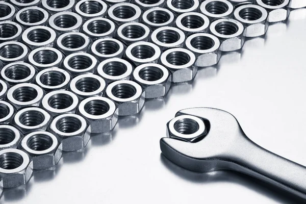 Metal nuts and wrench. Chrome vanadium tool on a white background. — Stock Photo, Image