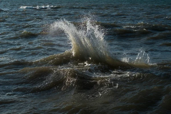 Splash van oceaan golven tegen de achtergrond van kalm water — Stockfoto