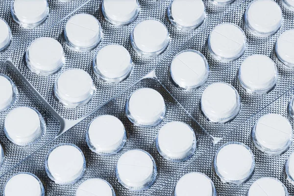 Weiße Pillen in silberner Verpackung auf weißem Hintergrund. — Stockfoto