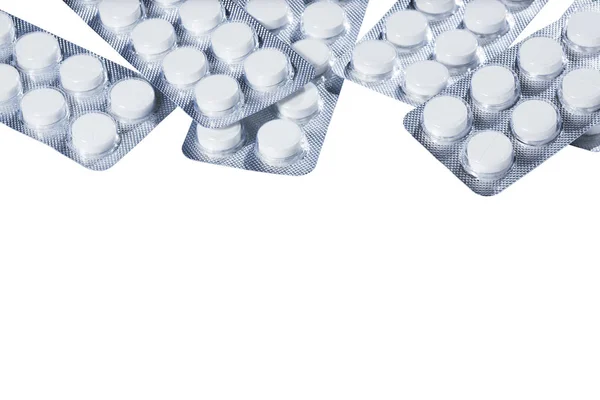 Pílulas brancas em embalagem de prata em um fundo branco . — Fotografia de Stock