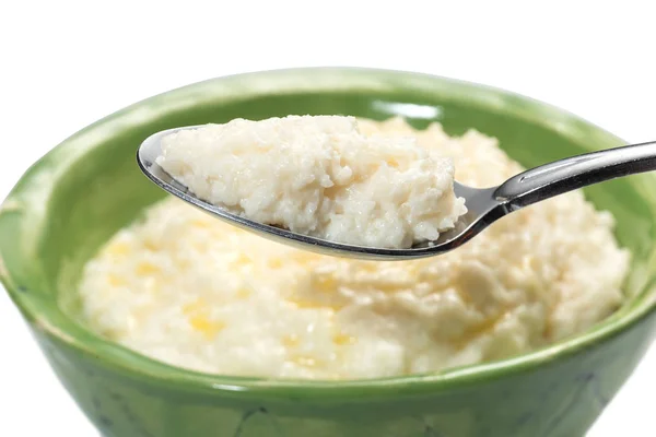 Rice porridge for breakfast with butter in a green bowl and spoon.