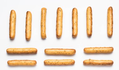 Gevrek breadsticks ile beyaz bir arka plan satırlarda düzenlenen haşhaş tohumu