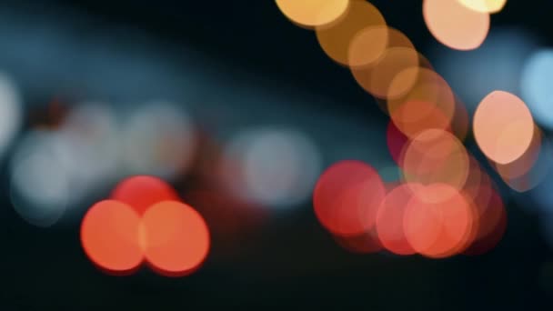 Τα φώτα της πόλης τη νύχτα. Defocused κυκλοφορία των αυτοκινήτων σε έναν πολυσύχναστο αυτοκινητόδρομο. — Αρχείο Βίντεο