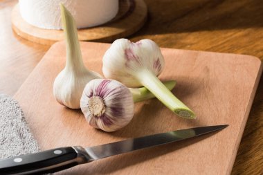 Mutfak masasında taze genç sarımsak ve bıçak