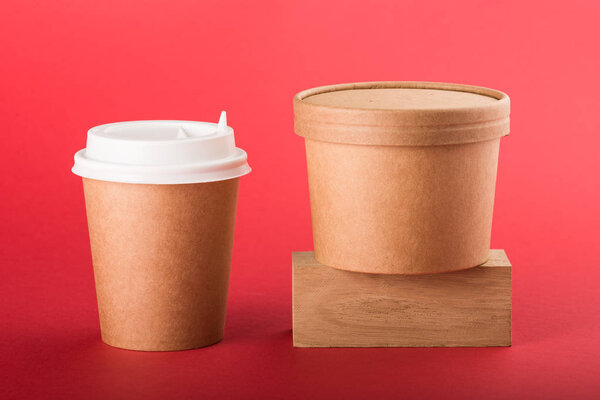 Disposable coffee cup and container for soup on a red background