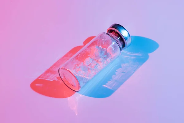 Renk aydınlatma bir aşı ile bir cam şişe. — Stok fotoğraf