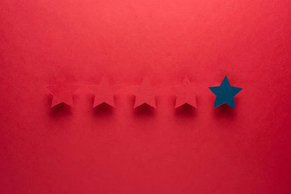 El concepto de retroalimentación o excelencia es diferente de todos, ser el primero. La estrella azul se destaca contra las rojas . — Foto de Stock